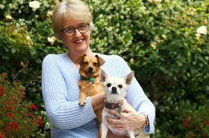 [Alt image text: Lost Dogs Home bequest supporter Jane cuddling her two rescue dogs. She is leaving a bequest gift in her Will to support the causes and charities that she cares passionately about.]